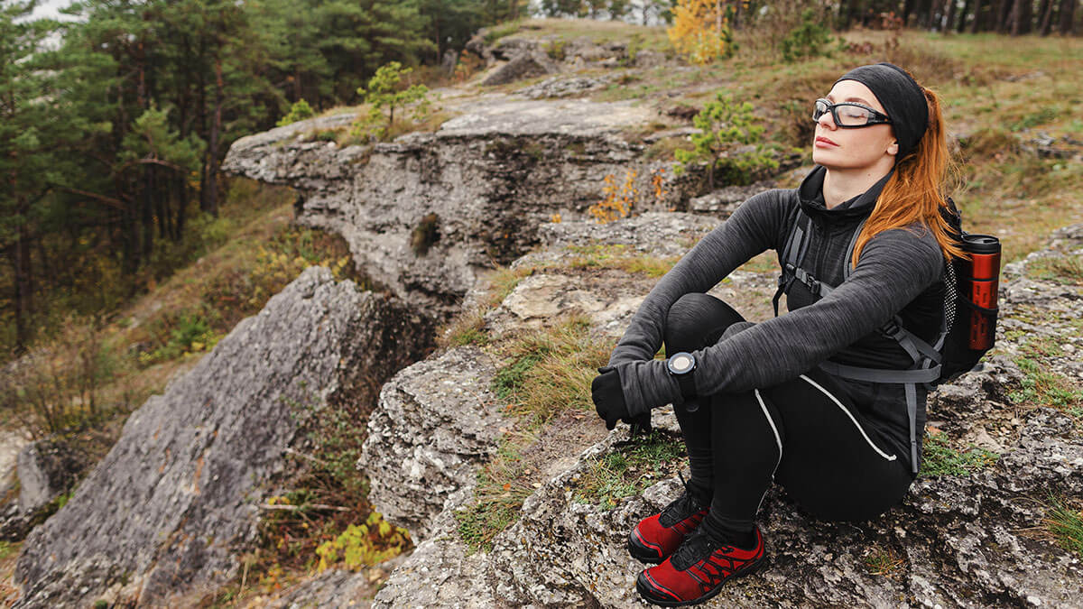 Femme seule se ressource en pleine nature - Bienfaits de la randonnée en famille